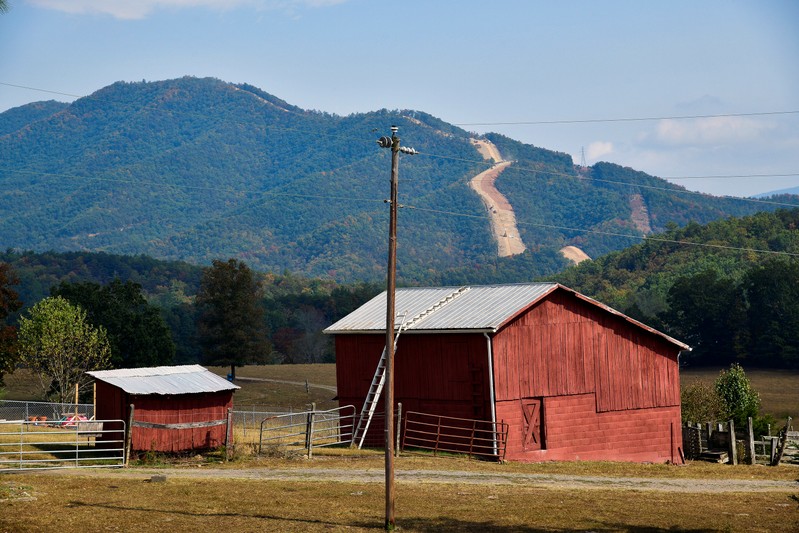 The Mountain Valley Pipeline rises along a ridge behind a rural farm near Elliston