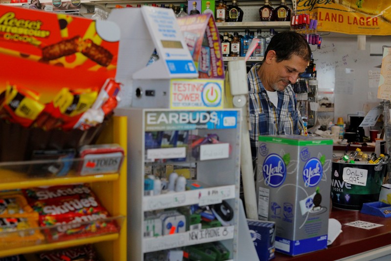 Convenience store owner Brad Khirfan stands at his counter in Flint