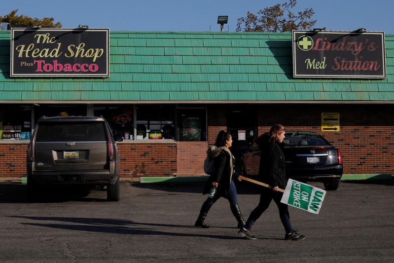 Striking union auto workers walk past local businesses around the GM Flint Truck Assembly in