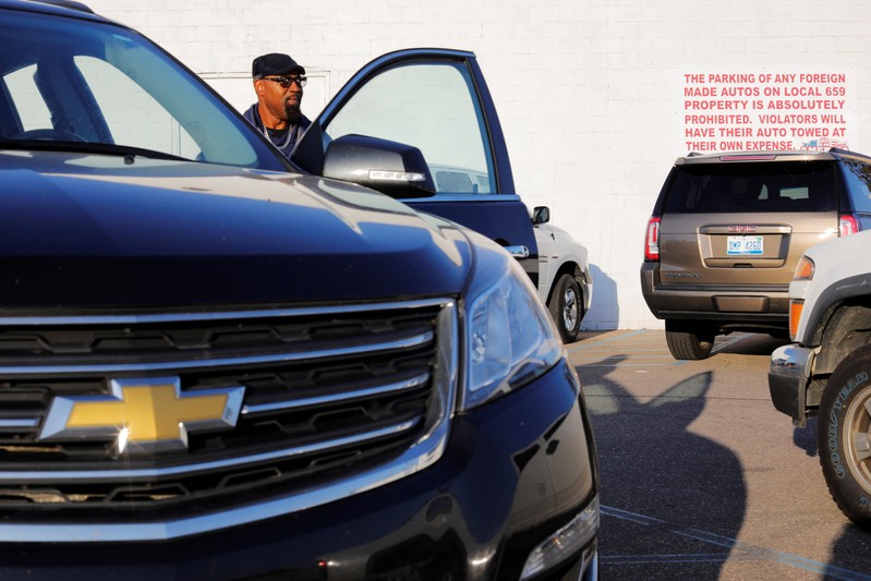 A striking union auto worker leaves the UAW Local 659 after picking up his strike check outside