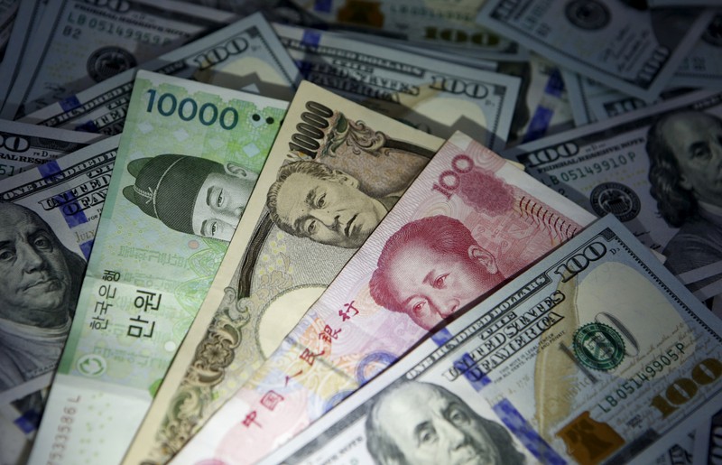 South Korean won, Chinese yuan and Japanese yen notes are seen on U.S. 100 dollar notes in this