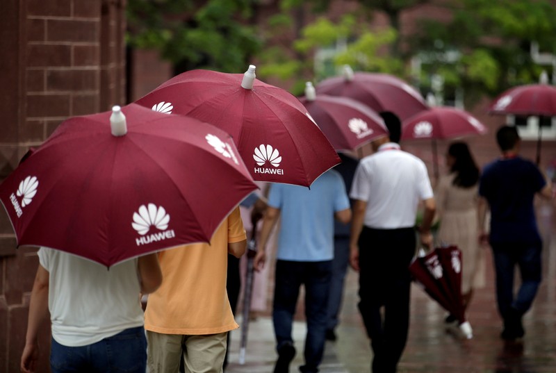FILE PHOTO: Guests hold umbrellas with Huawei logos in the rain at Songshan Lake New Campus in
