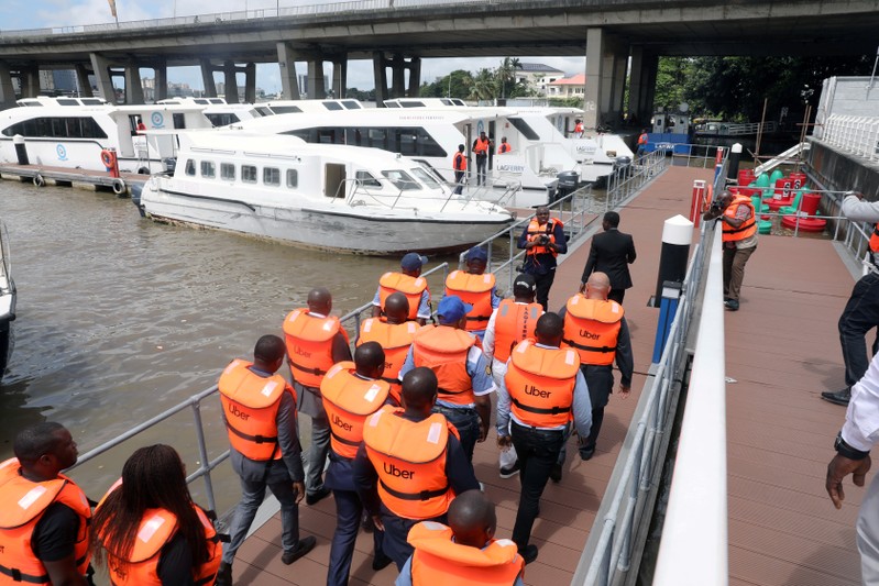 FILE PHOTO: Uber officials walk with life vests at the five cowries terminal during the
