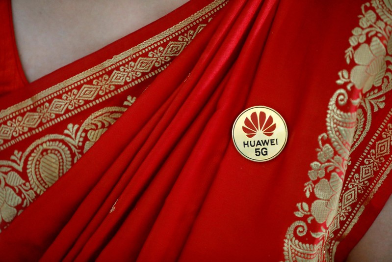 Huawei's logo is seen on a badge pinned on a saree of a lady at the India Mobile Congress in