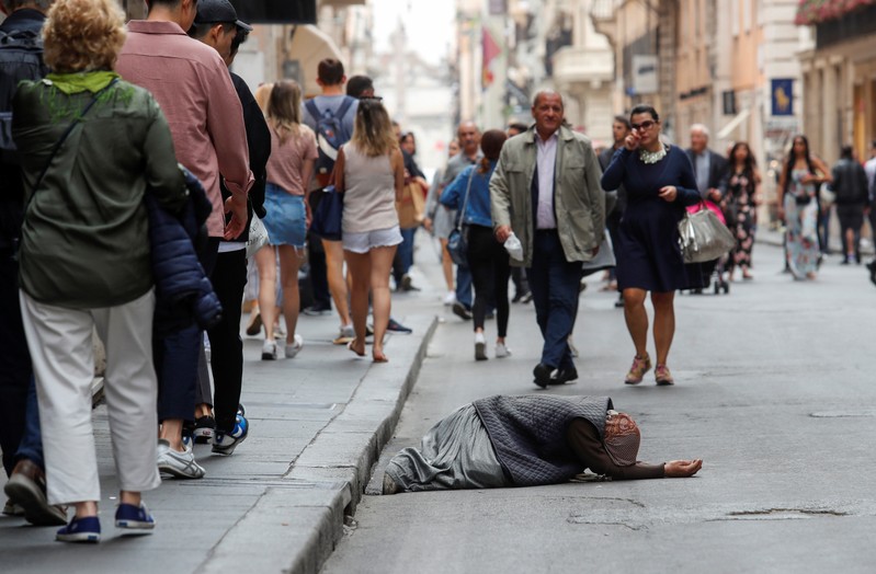 A beggar is seen in downtown Rome as Italy's cabinet prepares to approve a 2020 budget draft