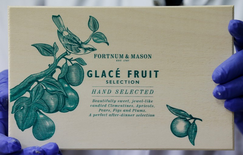 A worker displays a box of glace fruits to export to London's upmarket department store Fortnum