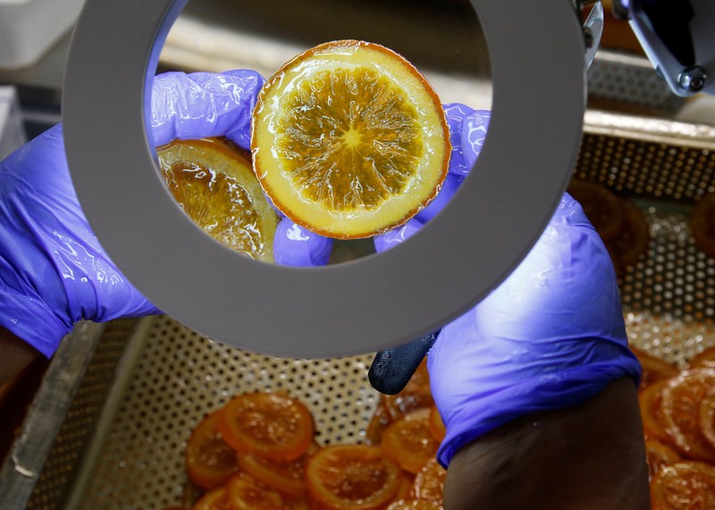 A worker checks candied slices of orange before export to Japan at the Cruzilles factory in