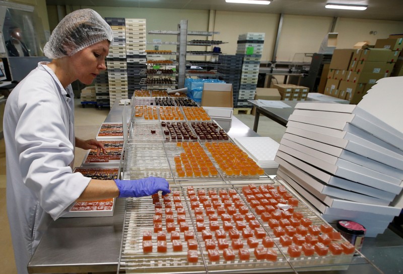 A woker prepares boxes of glace fruits and fruit jelly for export at the Cruzilles factory in