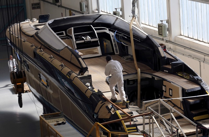FILE PHOTO: Employees work on a yacht at the Ferretti's shipyard in Sarnico