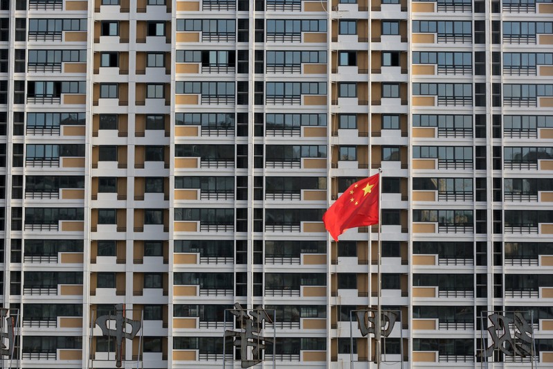 Chinese flag flutters in front of a residential building under construction in Huaian