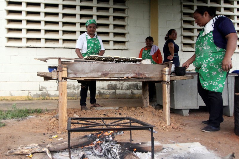 Volunteers help to prepare the meal for students at the San Agustin school in La Canada de