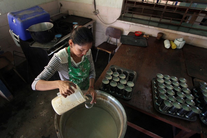 Volunteer helps to prepare breakfast for students at the San Agustin school in La Canada de