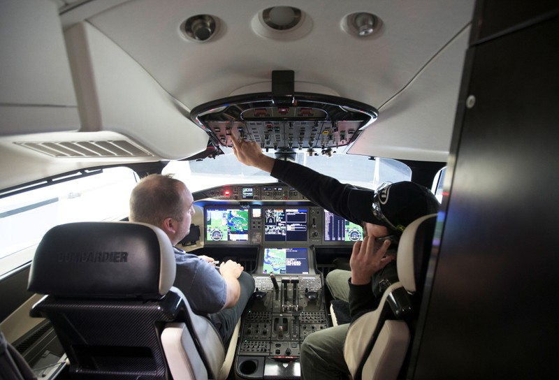 Employees make last minute adjustments in the cockpit of Bombardier's Global 7500, the first