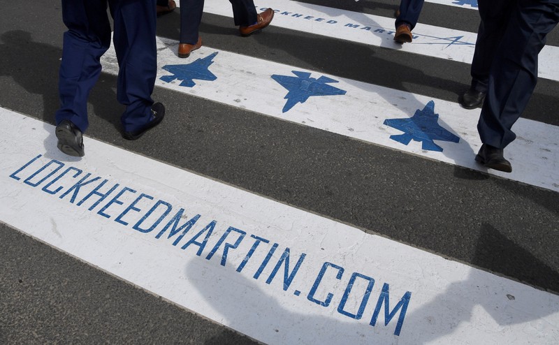 FILE PHOTO: Trade visitors are seen walking over a road crossing covered with Lockheed Martin