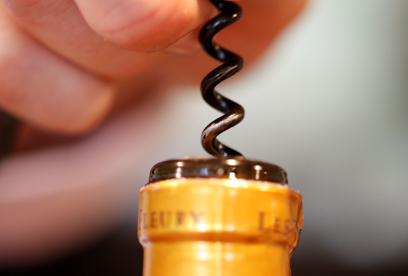 FILE PHOTO: A man opens a bottle of French wine with a corkscrew at the Chateau du Pavillon in
