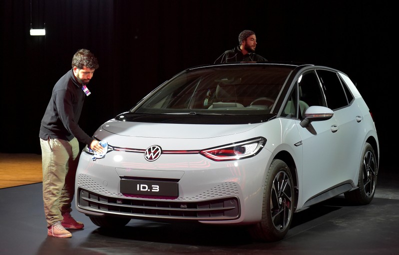 Employees clean a new car after a ceremony marking start of the production of a new electric