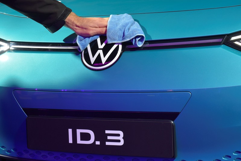 An employee cleans a logo of a new car after a ceremony marking start of the production of a