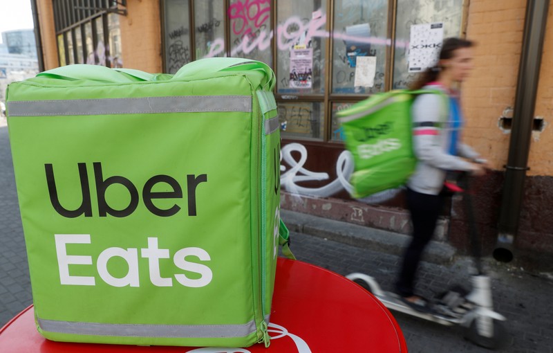 FILE PHOTO: An Uber Eats courier rides a scooter in Kiev