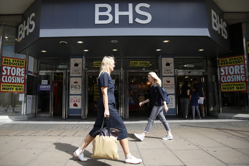 Pedestrians walk past a BHS store in London