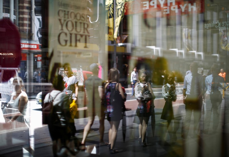 FILE PHOTO: Shoppers and workers on their lunch break are reflected in the window of a retail