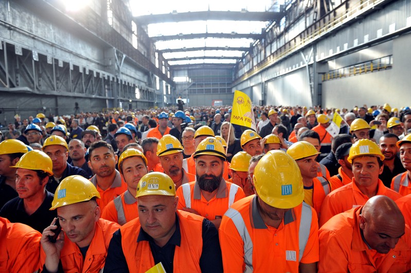 Workers from ILVA wait inside the steel plant for Pope Francis during his pastoral visit in
