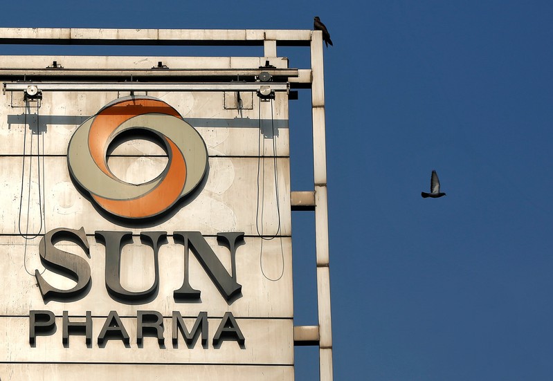 A bird flies past the logo of Sun Pharma installed on the facade of its corporate office in