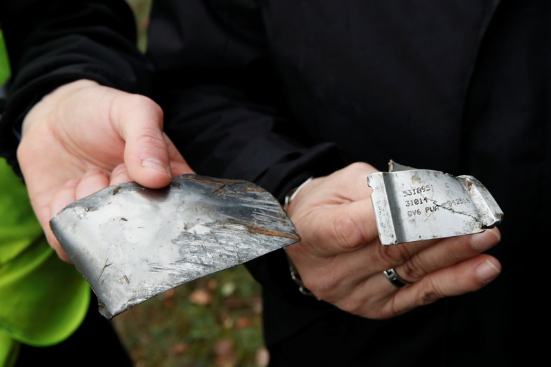 Members of the France's BEA aviation safety agency hold pieces of the engine of a Swiss Air