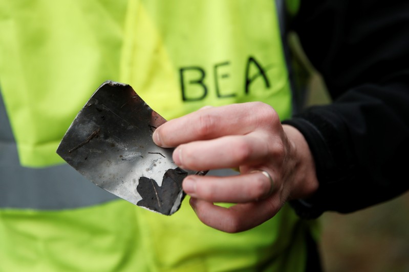 A member of the France's BEA aviation safety agency holds a piece of the engine of a Swiss Air
