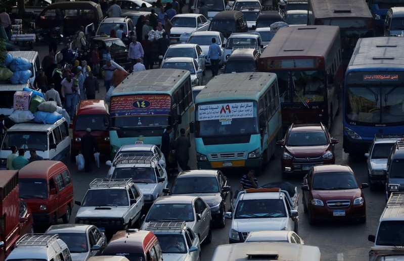 FILE PHOTO: People walk at a market amidst a traffic jam in downtown Cairo