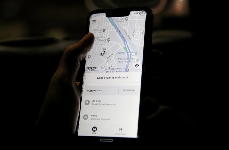A man uses Uber application on his mobile phone in Cairo