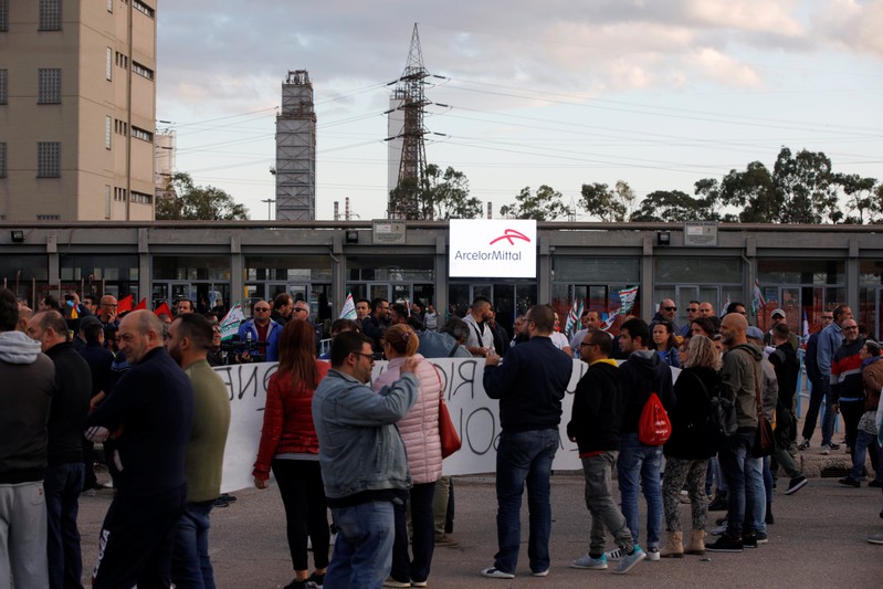 People wait for the arrival of Italian Prime Minister Giuseppe Conte outside the Ilva steel