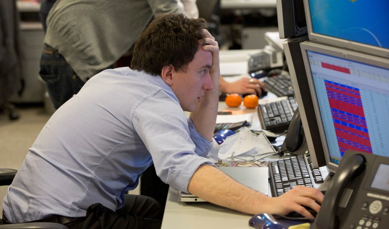 FILE PHOTO: A trader looks at his screen on the IG Group trading floor in London