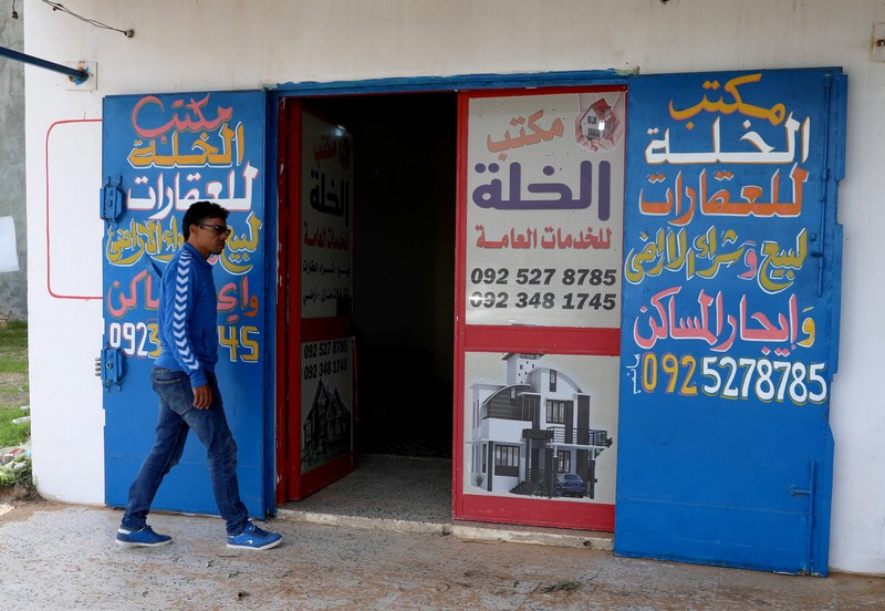 A man walks past a real estate office in Tripoli