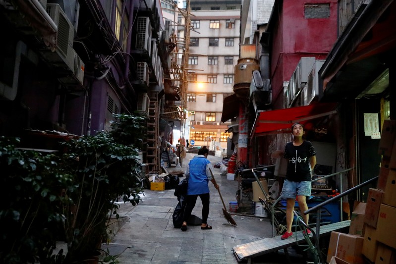 kbusFILE PHOTO: Woman stands outside a shop in an alley in Sheung Wan in Hong Kong