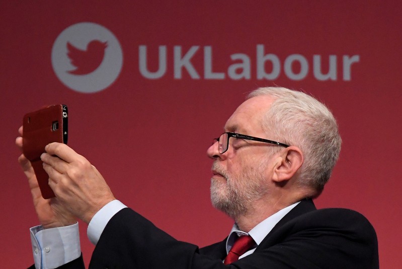 FILE PHOTO: Britain's opposition Labour Party leader Corbyn uses his smart phone whilst