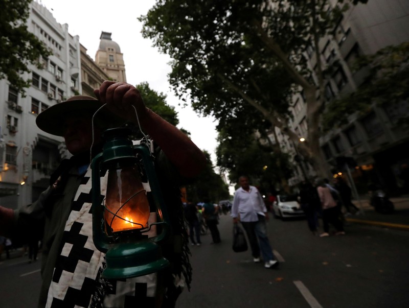 FILE PHOTO: A man wearing traditional Gaucho clothes holds a lantern