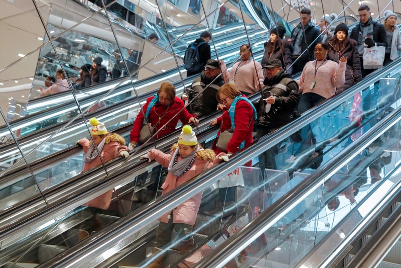 FILE PHOTO: People ride an escalator in H & M during a Black Friday sales event in Manhattan,