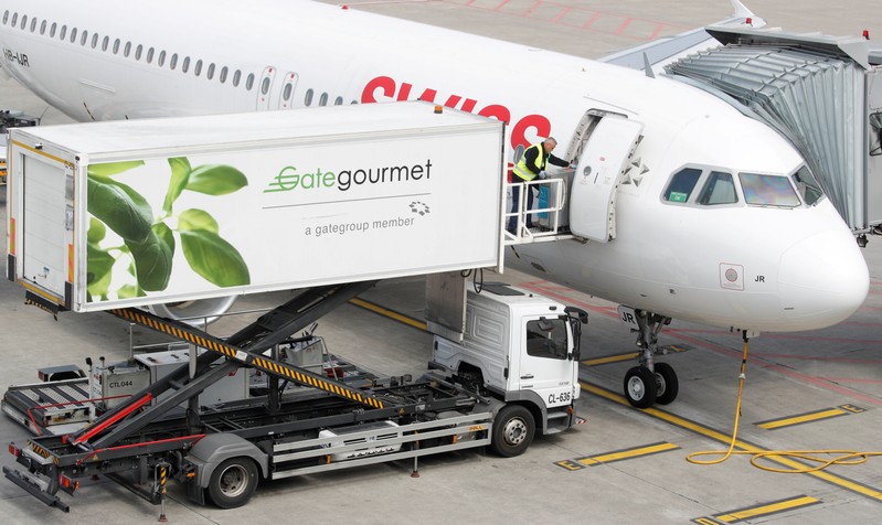 FILE PHOTO: Gate Gourmet staff loads a trolley aboard an Airbus A320-214 of Swiss airlines at