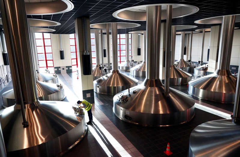 A worker inspects beer fermentation vats at Anheuser-Busch InBev brewery in Leuven