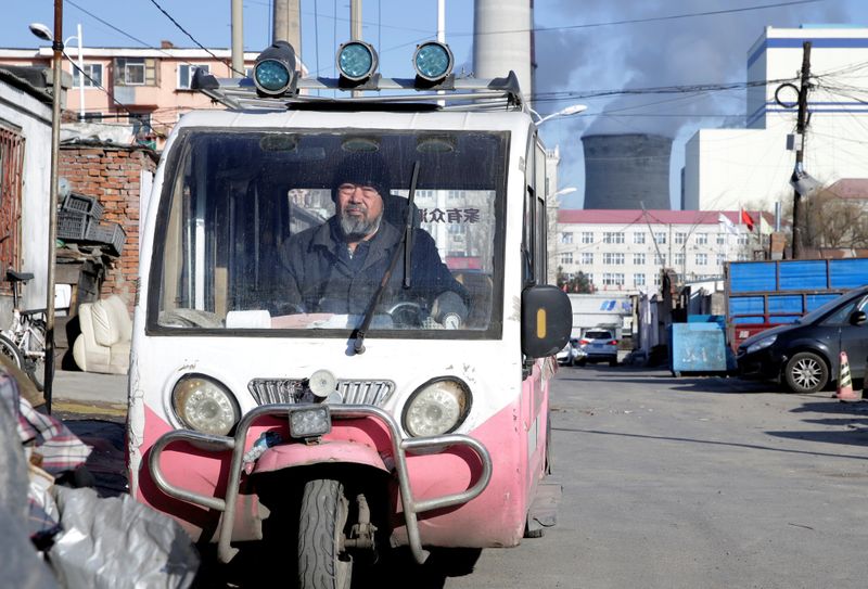 A man is seen in a motor tricycle near a coal-fired power plant in Harbin