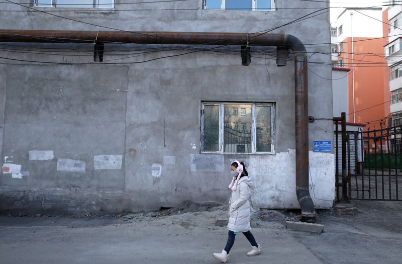 A woman walks past the gas pipeline settled into an old heating station, which is being changed