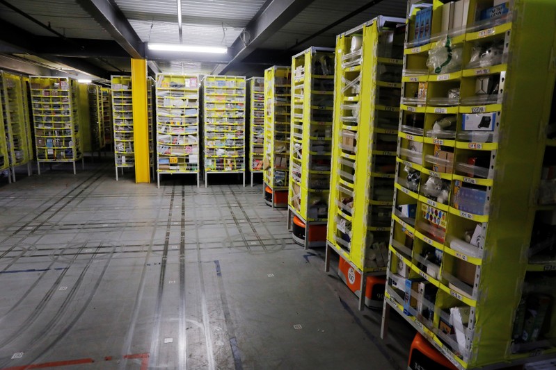 Tracks are left on the floor showing where robots carry shelves full of items inside of an