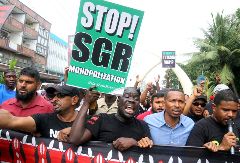 FILE PHOTO: Demonstrators hold signs against the Kenyan government during a protest in Mombasa