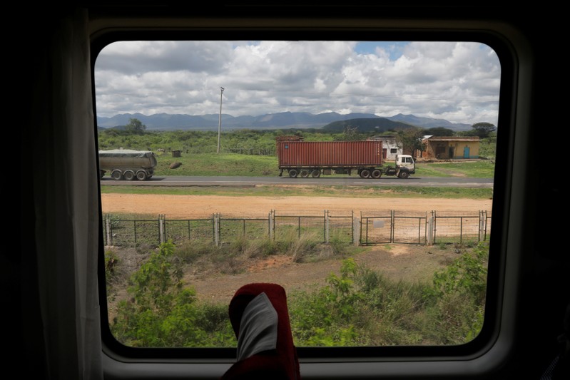 A truck is seen through a window of an SGR passenger train traveling on the Mombasa-Nairobi