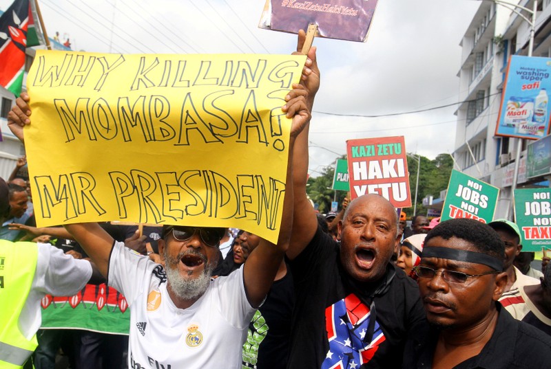 FILE PHOTO: Demonstrators hold signs against the Kenyan government during a protest in Mombasa