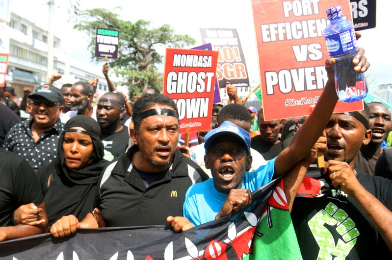 FILE PHOTO: Demonstrators hold signs against the Kenyan government during a protest in Mombasa