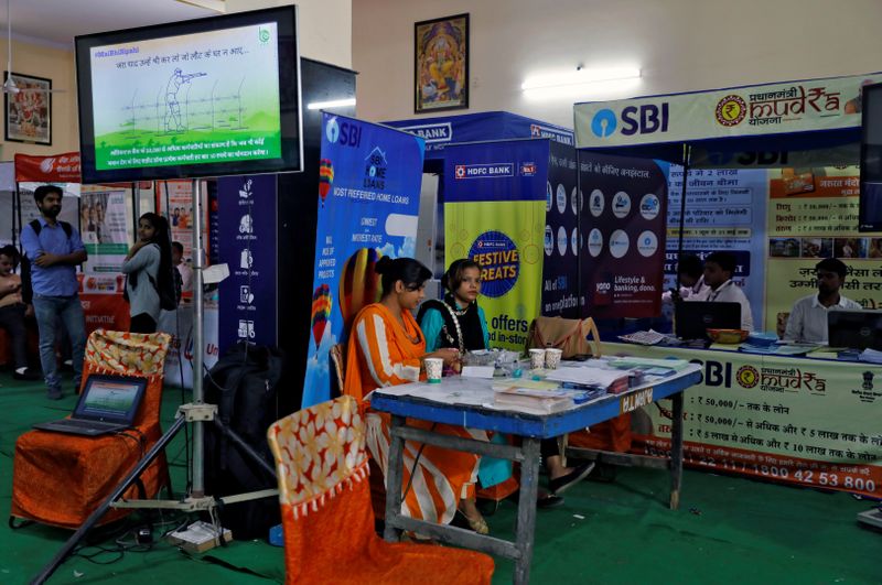 Employees of State Bank of India wait for customers to offer loans at a 