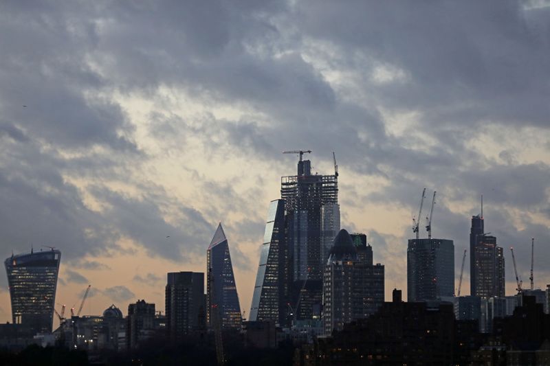 FILE PHOTO: The sun sets behind the Canary Wharf financial district of London
