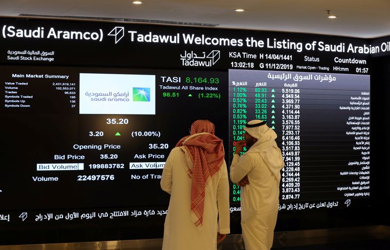 Man signs on a board at the Saudi Stock Exchange (Tadawul) following the debut of Saudi