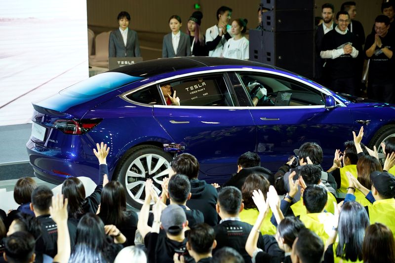 Tesla Inc CEO Elon Musk takes off his coat onstage during a delivery event for Tesla China-made